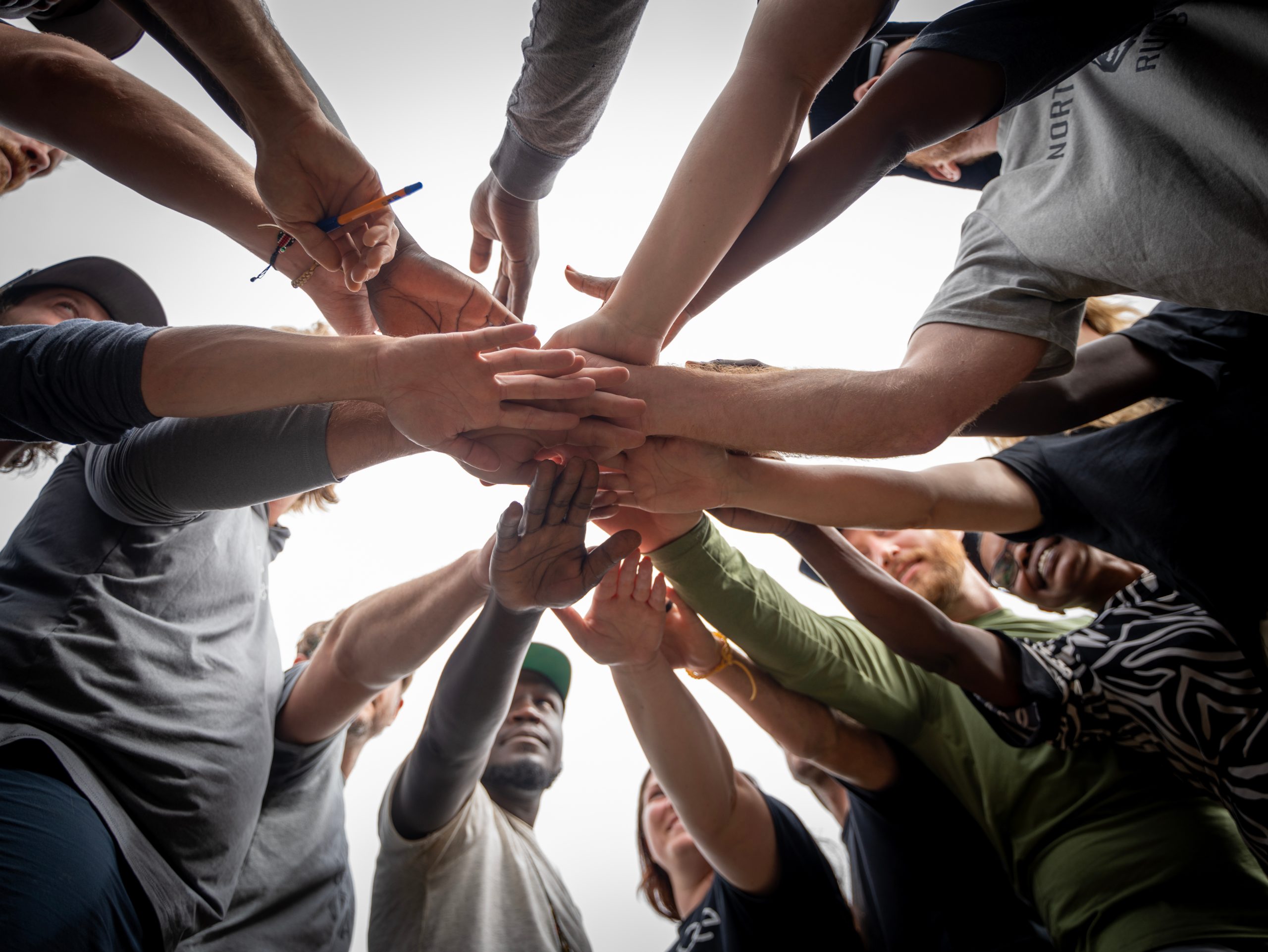 Hands of a team stacked together in a huddle